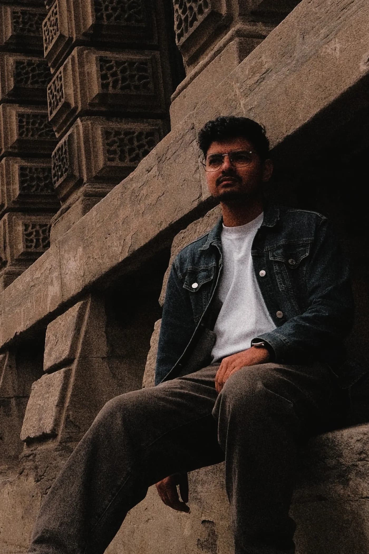 Prajwal Luitel seated on the stone steps of a building in Toronto